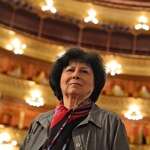 Carmen Moral standing in a large performance venue while looking at the camera.