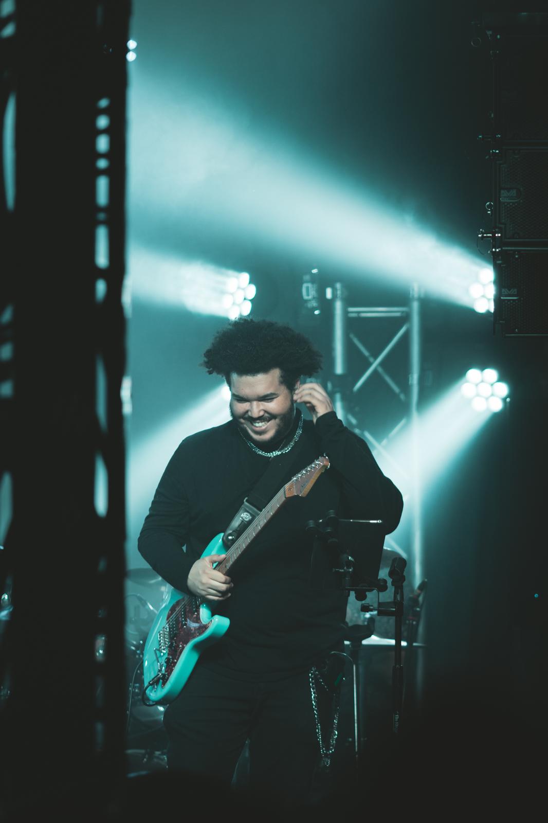 a man onstage with an electric guitar
