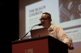 A picture of someone speaking at a podium. 