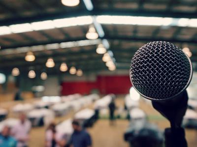 Close-up of microphone from the point of view of a speaker on stage