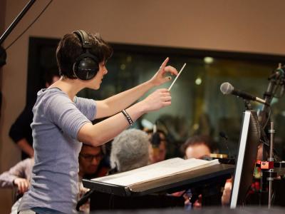 Person wearing headphones conducting an orchestra