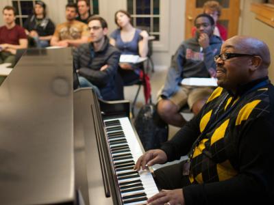 Teacher playing piano for students