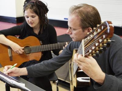 Guitar teacher and student marking up some sheet music