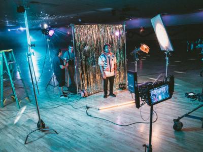 Crew using camera and lighting equipment to film in an empty club