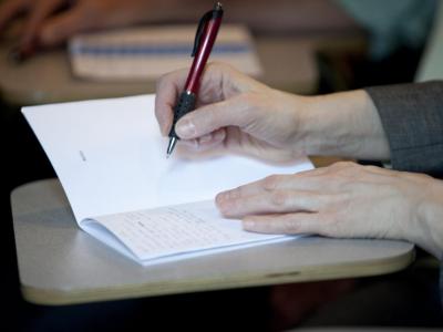 Close up of hands writing in a notebook