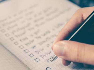 Close up of hand writing in a notebook with a pen