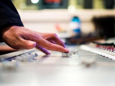 Human hand pushing a slider on a digital audio workstation