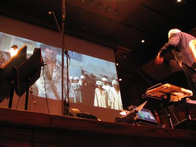 Film playing on projector in front of conductor