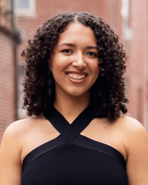 Chloe Swindler in a black dress in front of a brick building