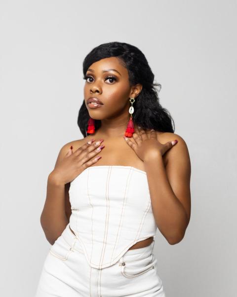 Vocalist Britani Washington poses in an all white outfit.