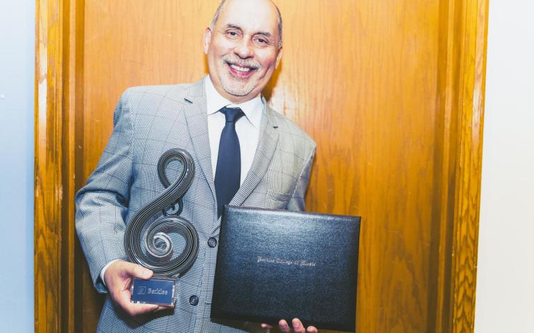 Humberto Ramirez holds his Master of Latin Music Award from Berklee