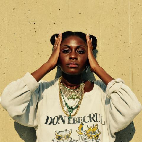 Image of Hip-Hop Artist SAMMUS posed against a tan concrete background