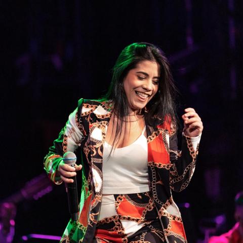 A woman vocalist dancing on stage