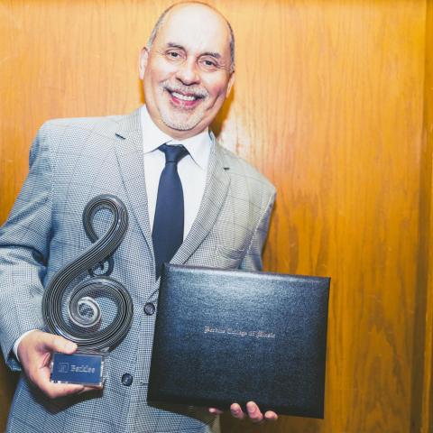 Humberto Ramirez holds his Master of Latin Music Award from Berklee