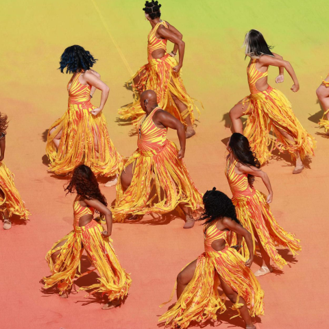 dancers dressed in yellow and orange perform in formation at FIFA world cup halftime show