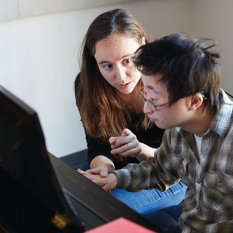 Woman assisting man with musical learning technology