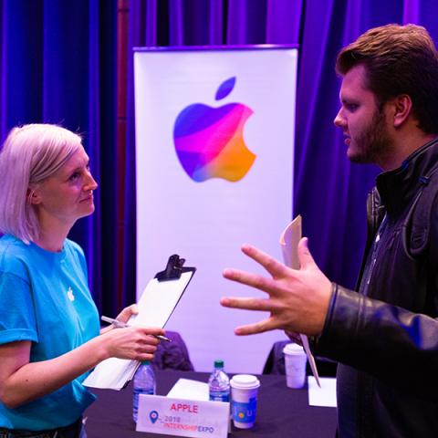 Representative from Apple talking with a student at the internship expo