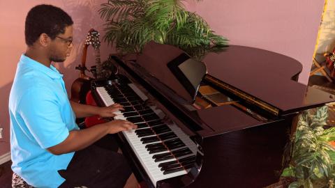 Dzidzor Amorin playing a baby grand piano