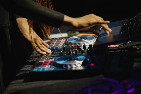 A woman's hands using a digital turntable and mixer