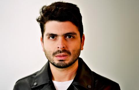 Kristhyan Benitez headshot, wearing a leather jacket and white t-shirt.