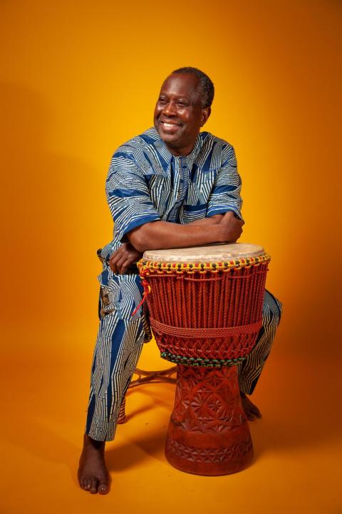 Moussa Traore resting his arms on a drum