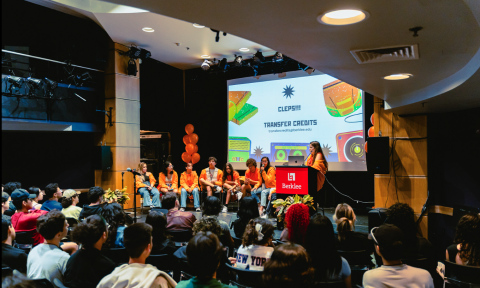Group of students seating next to each other on a stage 