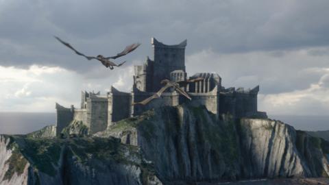 A scene from Game of Thrones season 8 where two dragons are flying in the foreground with Dragonstone in the background