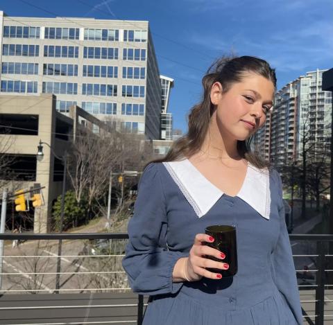 Girl, blue dress, sunny city behind her