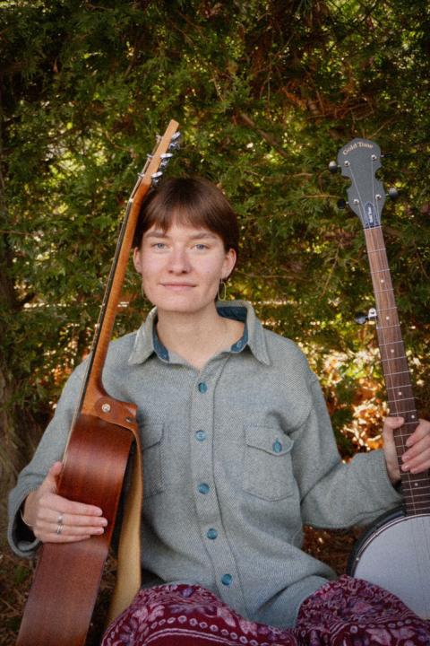 Maren Doughty sitting with two guitars