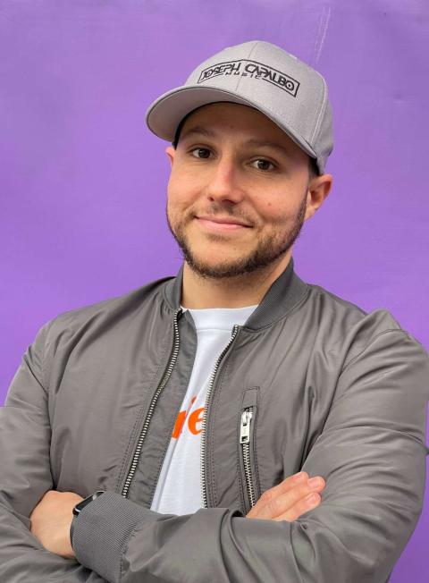 Joseph Capalbo with arms crossed standing against a blank background