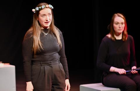 Aubrey Bosse (MM '25, voice) and Megan Jacobs (GPD '27, voice) perform on stage in dark clothing