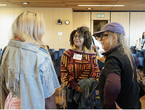 A group of people standing together smiling. 