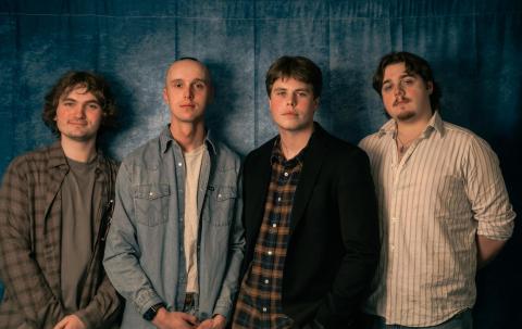 Good Sleepy posing against a moody gray backdrop