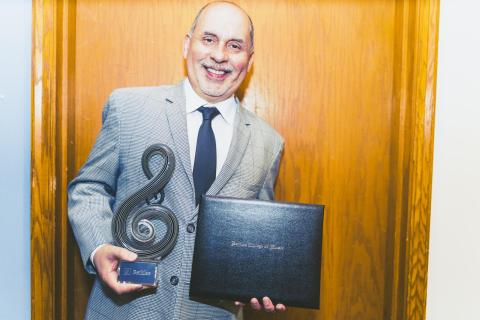 Humberto Ramirez holds his Master of Latin Music Award from Berklee