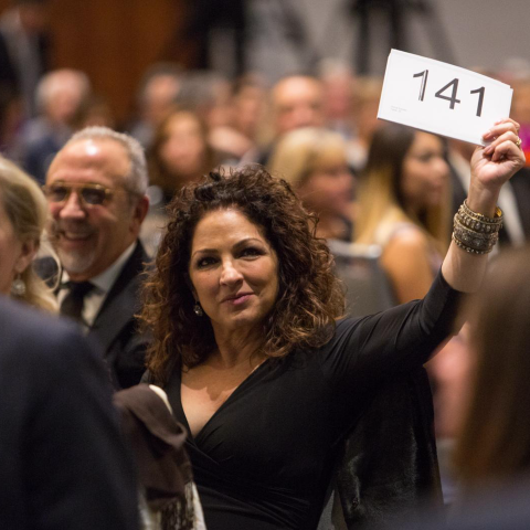 gloria estefan holding a bid card