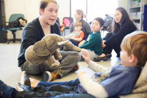 teacher holding elephant puppet for a child