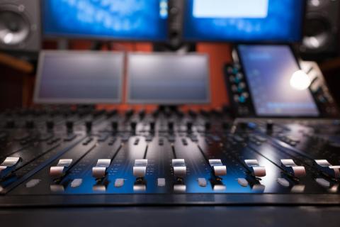 A digital recording console with monitors and multiple screens. 